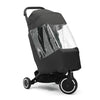 The image shows a black stroller with a protective rain cover on it. The cover has a clear plastic window on one side, allowing visibility inside the stroller. The stroller has three wheels: two smaller rear wheels and one larger front wheel with a white circular accent. The background is plain white, and the lighting is even and neutral, eliminating shadows.